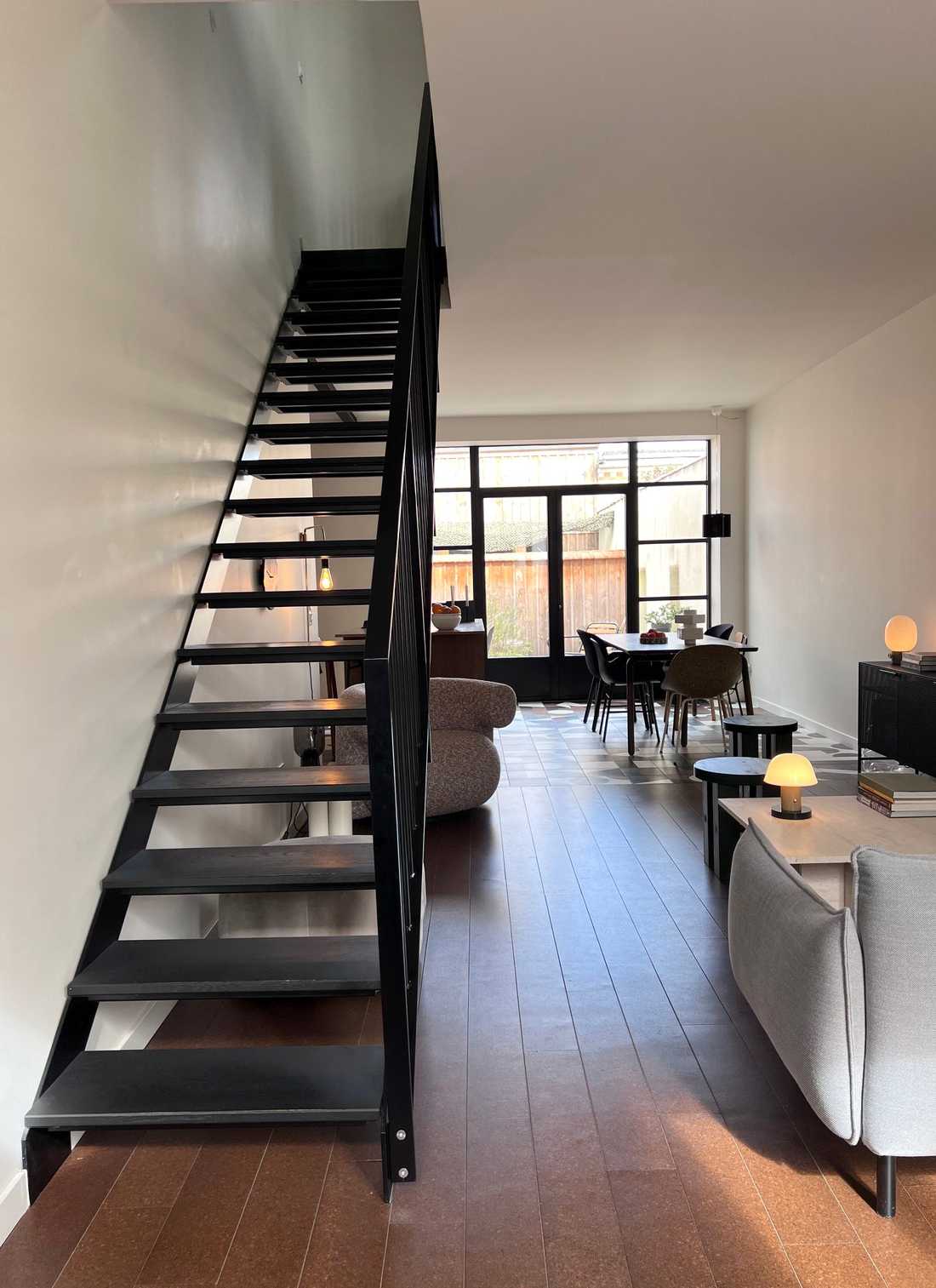 Vue d'un escalier en métal noir sur mesure et séjour